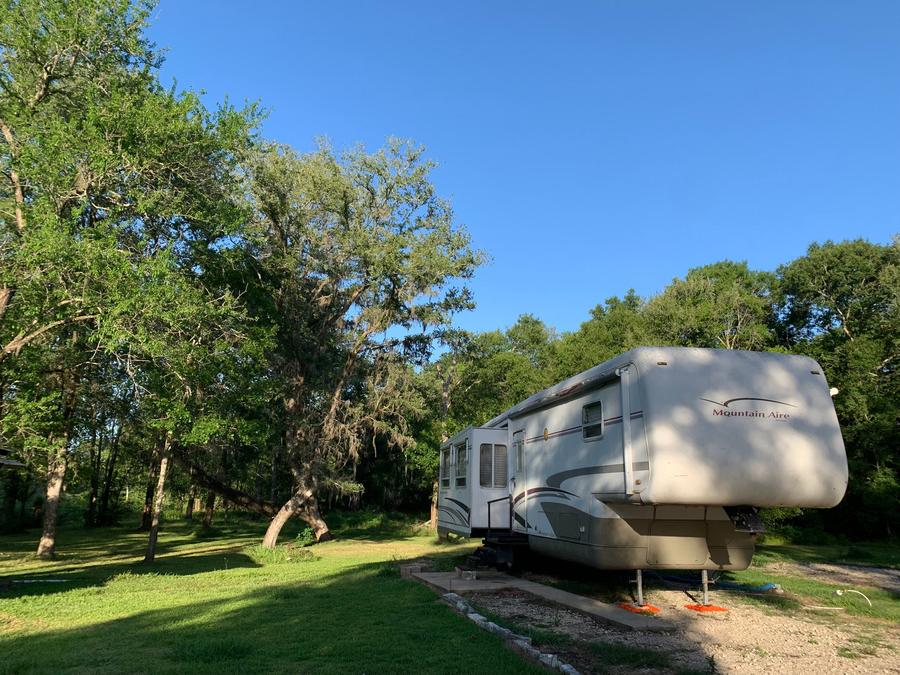 Fifth wheel RV on a site among the trees